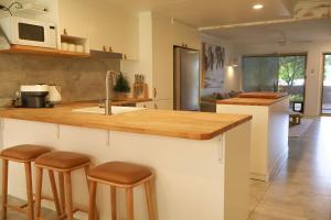 een keuken met een aanrecht met krukken en een wastafel bij Beach Street - LJHooker Yamba in Yamba