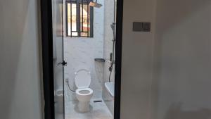 een badkamer met een toilet en een raam bij Danshome in Moshi +14 foto's