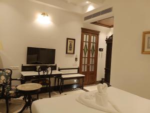 a living room with a bed and a desk with a piano at The Anthill in Bolpur