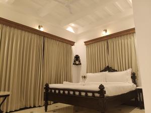 a bedroom with a large bed with white pillows at The Anthill in Bolpur