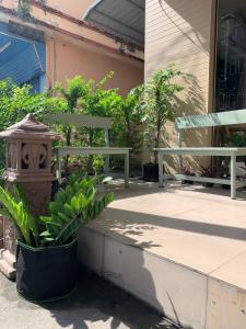 een veranda met een bank en een plant bij Uncle Yo House in Ban Tha Khreng