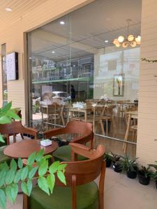 een restaurant met houten tafels en stoelen en een raam bij Uncle Yo House in Ban Tha Khreng