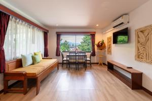 ein Wohnzimmer mit Sofa und Tisch in der Unterkunft Aochalong Villa Resort & Spa - SHA Plus in Chalong 
