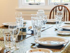 una mesa con vasos y platos encima en Mark Farmhouse, en Bradwell on Sea