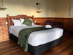 a bedroom with a large bed and a chair at Highlander Van Village in Armidale +19 photos