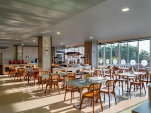 RembangにあるAston Inn Rembangのテーブルと椅子とキッチンのあるレストラン