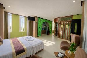 a bedroom with green walls and a bed and chairs at Phương Anh 7- Only accept Vietnamese customers in Danang