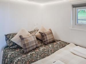 a couch with pillows in a room with a window at Tyan - Uk49354 in Gatebeck