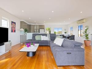 een woonkamer met een bank en een tafel bij Baravi Breeze Retreat in Safety Beach