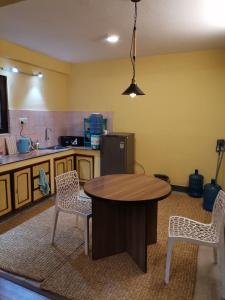 Una cocina con una mesa de madera y dos sillas. en Purposeful Travel Planner- Homestay, Culture & Volunteering, en Pātan