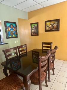 a dining room with a table and chairs and paintings at Casa Doña Anita in León