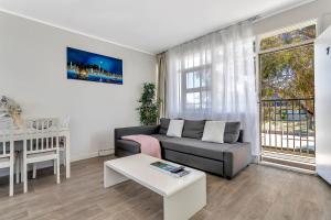 a living room with a couch and a table at Walk to Beach And Cafes Near City And Airport in West Beach