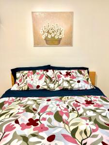 een slaapkamer met een bed met een bloemenbed bij Private Entire Guest Suite, 1 min to bus stops to Downtown and major attractions in Vancouver