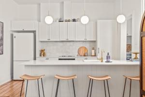 een keuken met witte kasten en een aanrecht met krukken bij The Countess in Launceston