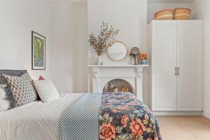 een witte slaapkamer met een bed en een open haard bij The Countess in Launceston