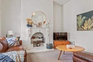 een woonkamer met een bank en een spiegel bij The Countess in Launceston