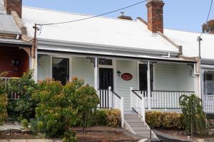 een wit huis met een witte veranda en een trap bij The Countess in Launceston