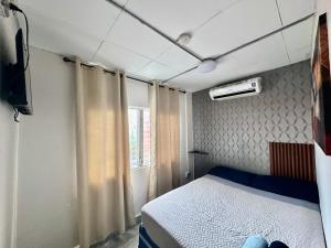 ein Schlafzimmer mit einem Bett, einem Fernseher und einem Fenster in der Unterkunft Apartment in downtown David in David