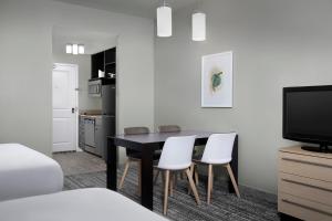 a dining room with a black table and white chairs at Towneplace Suites Dallas Desoto in DeSoto