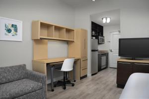 a living room with a desk and a couch and a television at Towneplace Suites Dallas Desoto in DeSoto
