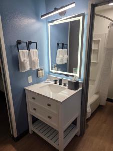 Un baño con un lavabo blanco y un espejo. en Big Sky Inn, en Missoula 15 fotos más