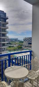 a table and chairs on a balcony with a view at Sea Residences MoA Manila by 7J in Manila