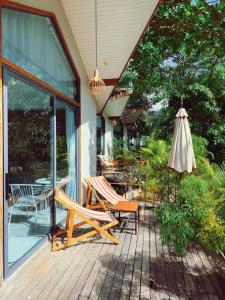 a patio with two chairs and an umbrella at Crystal Bungalow DELUXE in Ko Phangan