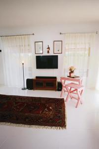 un salon avec une télévision à écran plat et une table dans l'établissement Windy's Leisure Villa, à Negombo