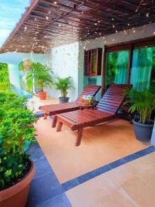 un patio avec deux bancs en bois et des plantes en pot dans l'établissement Windy's Leisure Villa, à Negombo