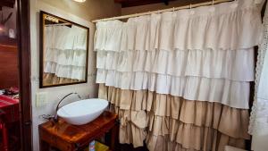 Un baño con una cortina de ducha blanca y un lavabo. en Cabaña 'Te para Tres' Merlo San Luis, en Merlo