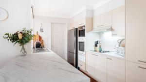 a kitchen with white cabinets and a marble counter top at La Playa in Myola