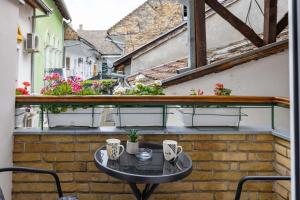 a small table on the balcony of a building at Old City Rooms in Novi Sad