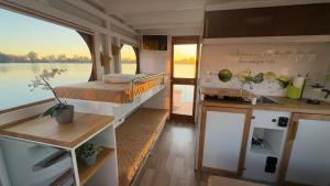 a kitchen and a bed in a small boat at Hausboot in Berlin, festliegend im Yachthafen Schmöckwitz, mit Heizung in Berlin