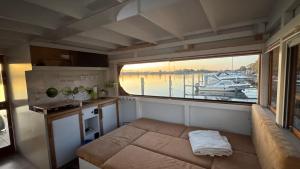 a room with a couch and a window in a boat at Hausboot in Berlin, festliegend im Yachthafen Schmöckwitz, mit Heizung in Berlin +5 photos