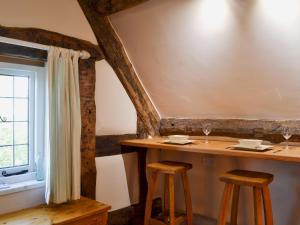 a table with two stools next to a window at Lees Farm Apartment in Walcot