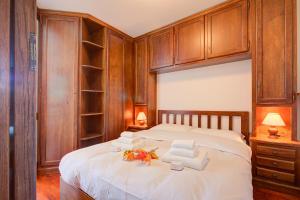 a bedroom with a large bed with wooden cabinets at Appartamento Principino 24 Ski in Ski out - Happy Rentals in Sestriere