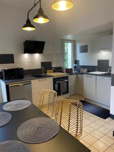 a kitchen with a table and chairs in it at Le Saint Symphorien 4 in Longeville-lès-Metz
