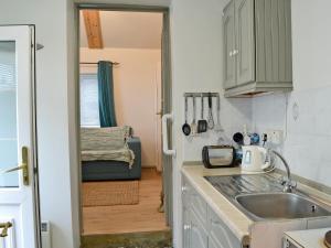 een kleine keuken met een spoelbak en een koelkast bij The Pocker Watch in Chideock
