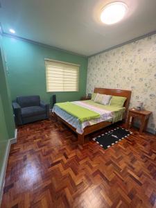 une chambre avec un lit et une chaise dans l'établissement Palacios Residences, à Iloilo