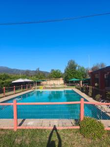 una grande piscina con recinzione intorno di domos anmile a Los Quillayes