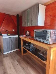 una cucina con forno a microonde e fornello forno superiore di domos anmile a Los Quillayes