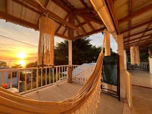 una hamaca en un porche con la puesta de sol en el fondo en Cabaña sunrise view, en Providencia