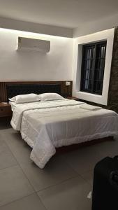 ein großes weißes Bett in einem Schlafzimmer mit Fenster in der Unterkunft 120 desinganad nagar asramom in Kollam