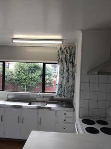 una cocina con fregadero y ventana en Napier Nest Motel, en Napier