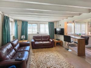 een woonkamer met een leren bank en een televisie bij Tyn Y Celyn - Uk48801 in Mold +5 foto's