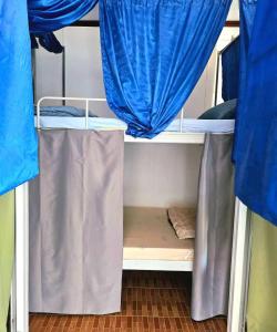 een kamer met 2 stapelbedden en blauwe gordijnen bij west water hostel in Vang Vieng