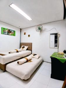 een kamer met twee bedden en een tafel erin bij Omah Jamblangan in Cebongan