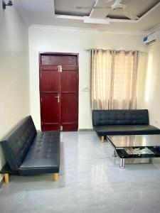 een kamer met twee zwarte leren banken en een rode deur bij Leo Home 1 in Nungwi