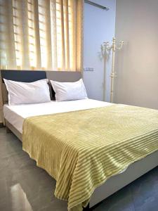 een slaapkamer met een groot bed met een gele deken bij Leo Home 1 in Nungwi