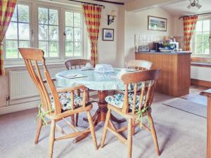 una sala da pranzo con un tavolo e quattro sedie di The Mansion Cottage a Tetford